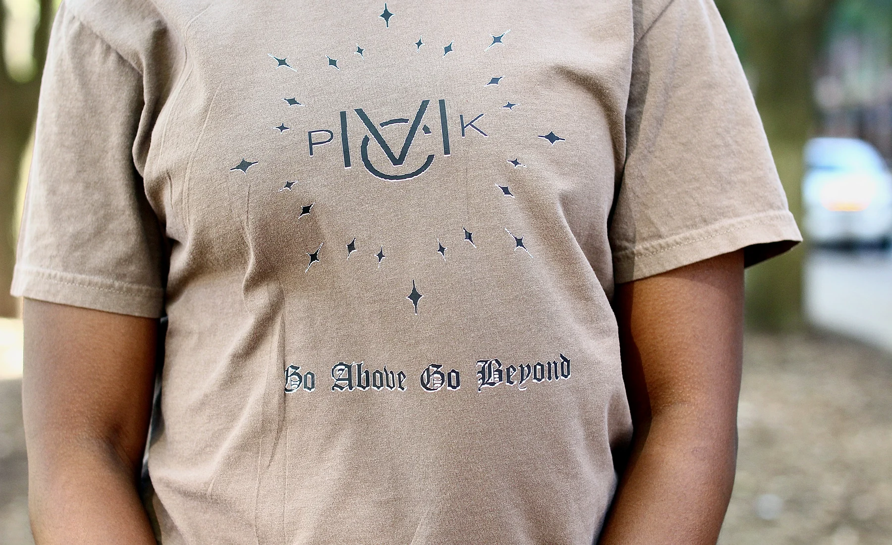 Model wearing the Day 52 tee, front print reading Go Above Go Beyond